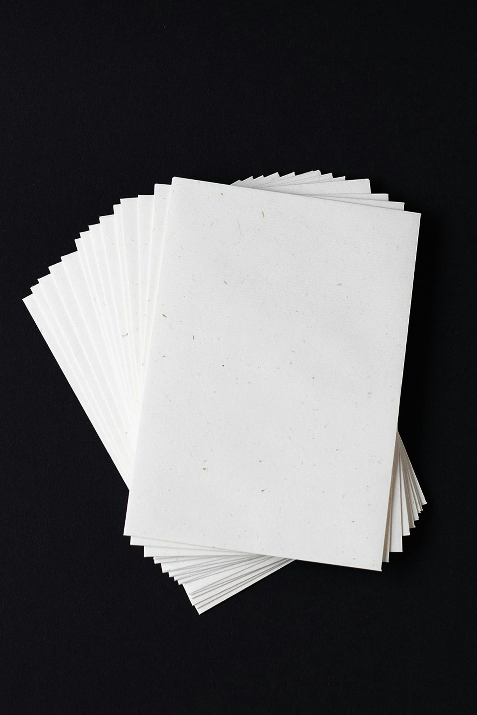 Stack of white envelopes on a black background with ample copy space, ideal for stationery design.